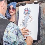 Ben Vincent drawing a caricature of a women with blue hair