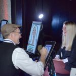 Women with blonde hair getting digital caricature done